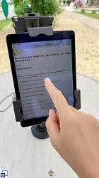 Hand zeigt auf ein Tablett mit der angezeigten Umfrage
