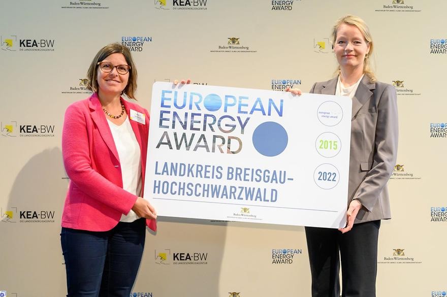 Sabine Barden und Ministerin halten gemeinsam ein EEA-Banner und lächeln in die Kamera.          