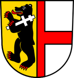 Wappen mit einem schwarzen Bären, der ein silbernes Kreuz schultert.