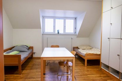 Zweibettzimmer mit Schrank und eine Tischgruppe in der Mitte