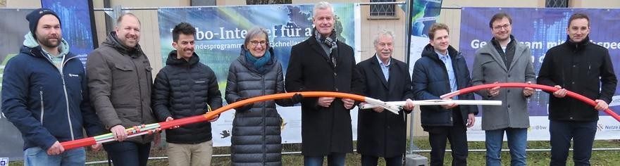 Die Beteiligten halten zusammen ein Glasfaserkabel.