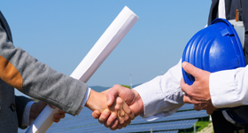 Zwei Personen schließen einen Bauvertrag per Handschlag ab