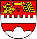 In Rot über einem silbernen weißen) Dreiberg ein silberner Balken mit sieben Zinnen, darüber ein goldener Rebzweig mit goldenem Blatt und goldener Traube